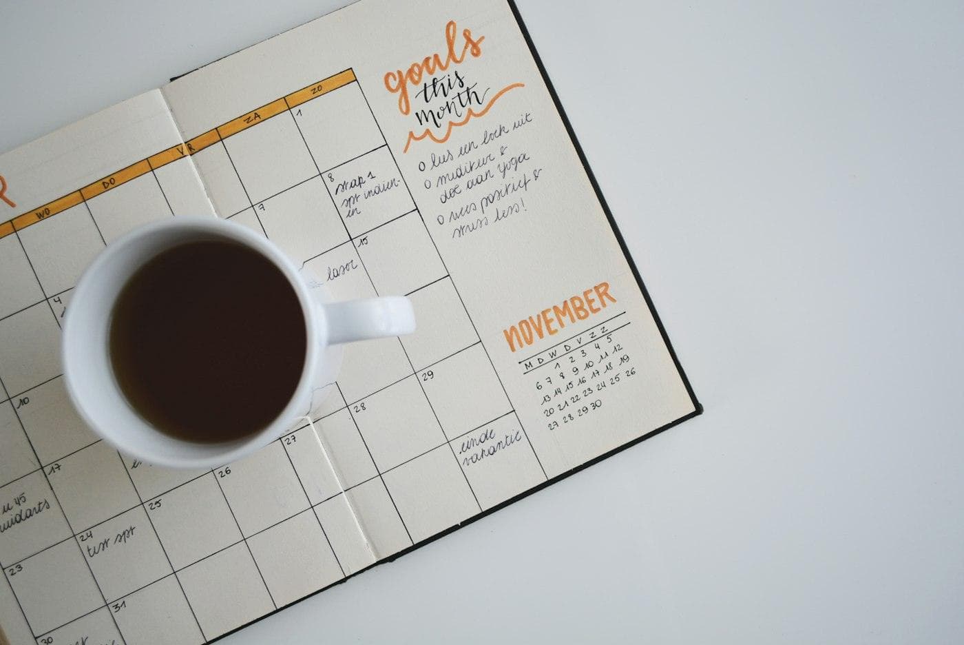 Calendrier papier et tasse de café sur un bureau blanc
