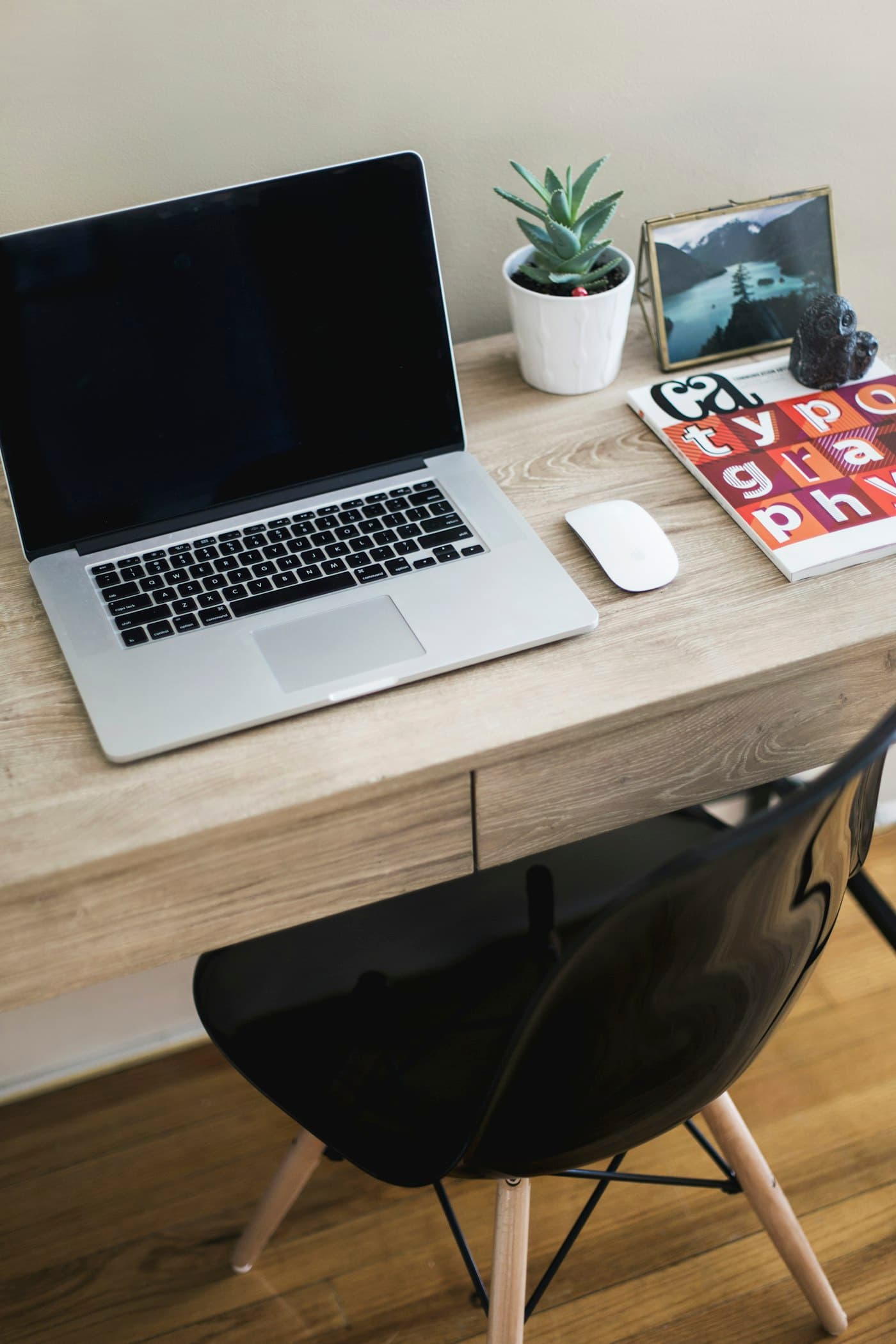 Ordinateur portable sur un bureau en bois, avec une plante